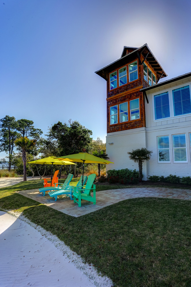 ラグジュアリーなビーチスタイルのおしゃれな家の外観 (漆喰サイディング) の写真