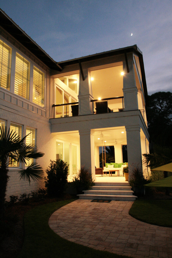 Пример оригинального дизайна: большой, двухэтажный, белый дом в морском стиле с облицовкой из цементной штукатурки и двускатной крышей