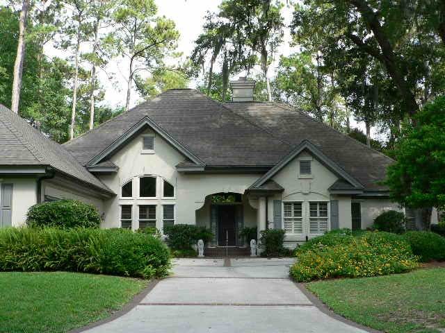 This is an example of a medium sized and beige traditional bungalow render detached house in Jacksonville with a hip roof and a shingle roof.