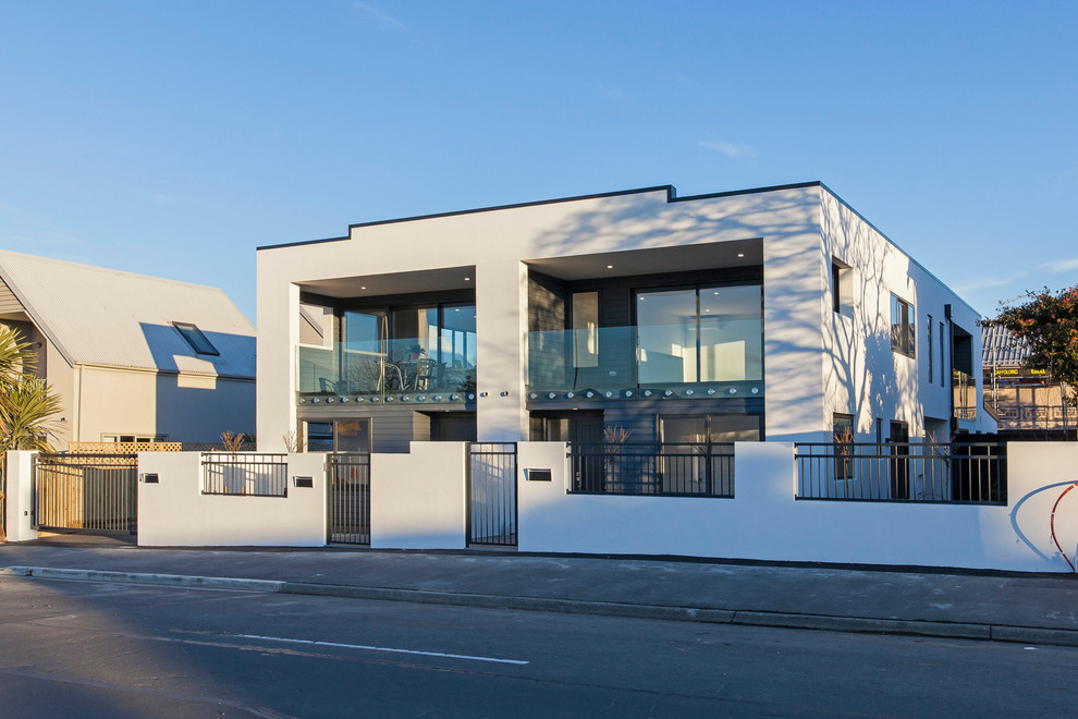 Kleines, Zweistöckiges Modernes Wohnung mit Putzfassade, weißer Fassadenfarbe, Flachdach und Blechdach in Christchurch
