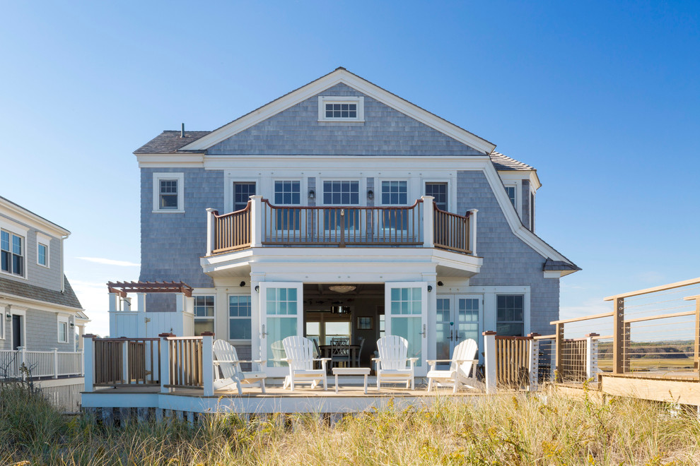 Cette photo montre une grande façade de maison bleue bord de mer à deux étages et plus avec un toit à deux pans.