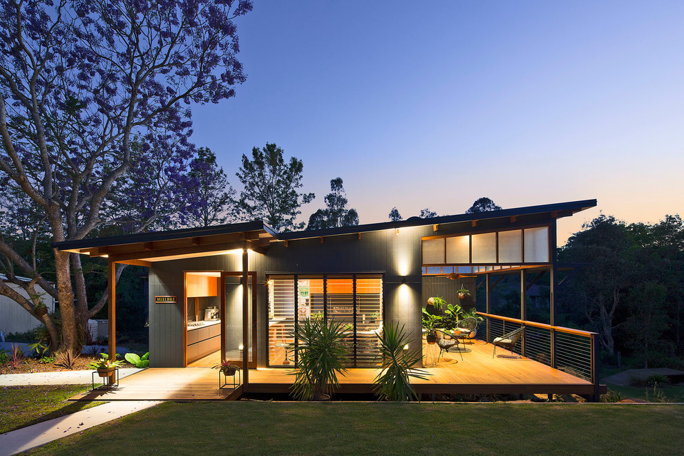 Inspiration for a small and black modern bungalow detached house in Brisbane with concrete fibreboard cladding, a flat roof and a metal roof.