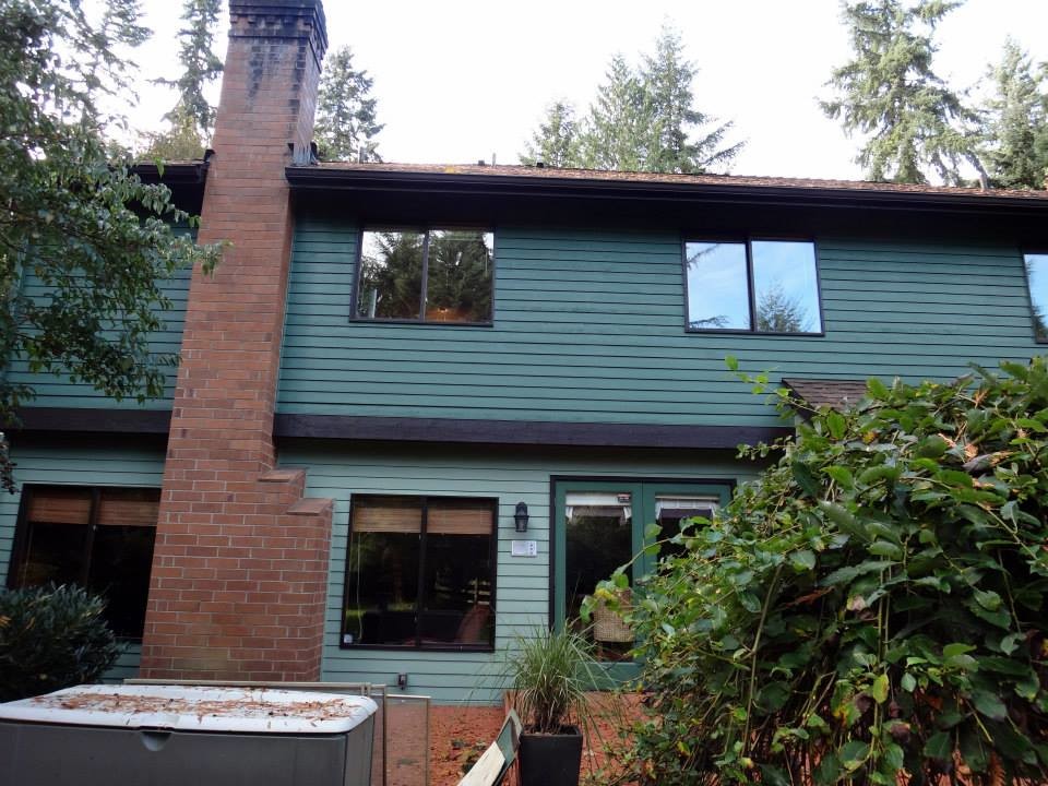 This is an example of a medium sized and green classic two floor house exterior in Seattle with mixed cladding and a hip roof.