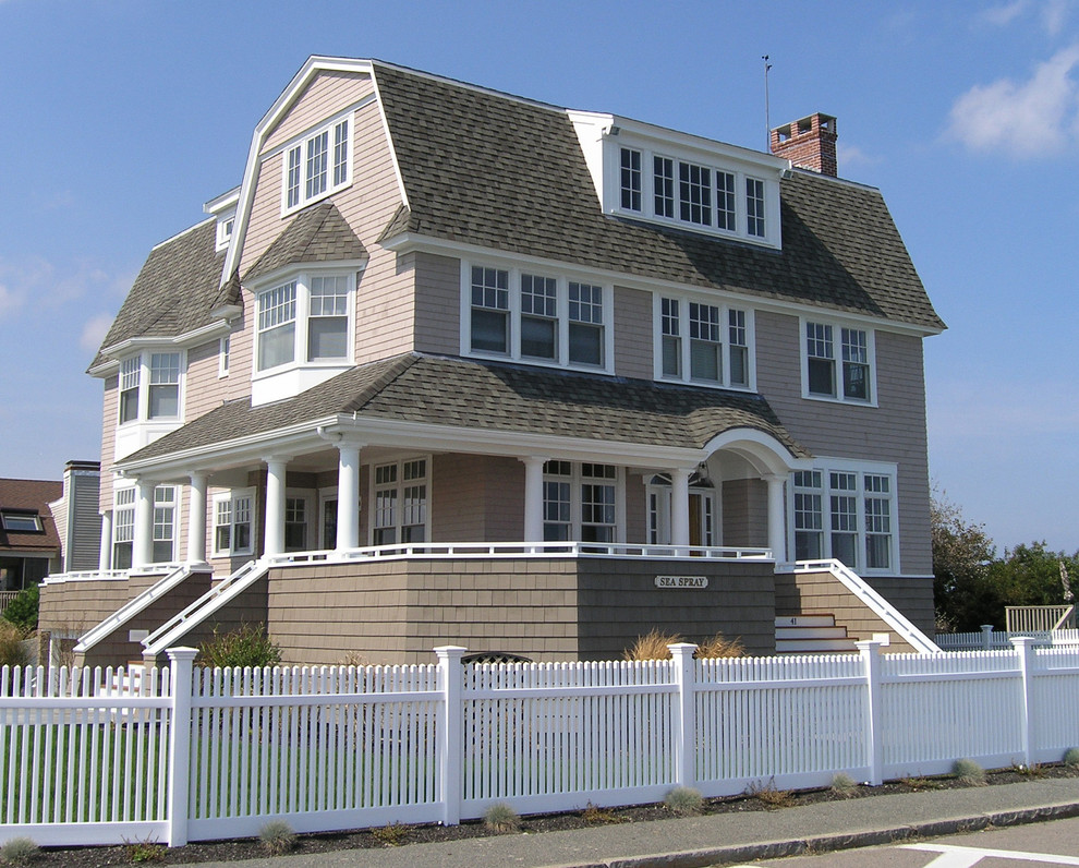 Cette photo montre une grande façade de maison beige bord de mer en bois à deux étages et plus avec un toit de Gambrel et un toit en shingle.
