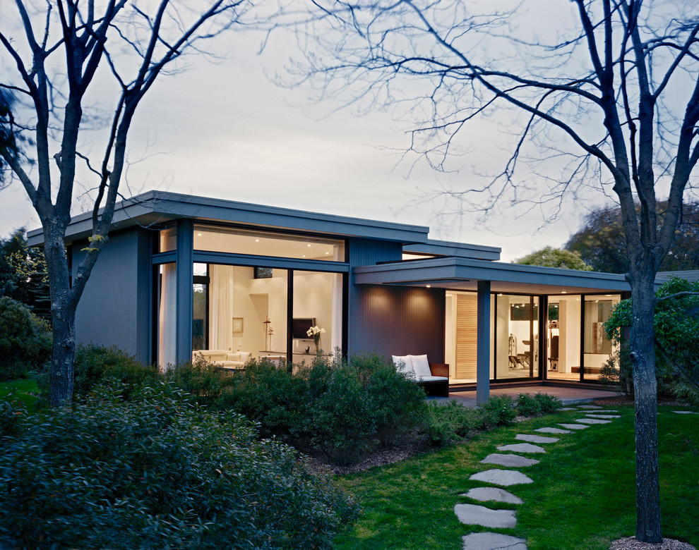 Пример оригинального дизайна: одноэтажный, стеклянный, серый дом среднего размера в стиле модернизм с плоской крышей