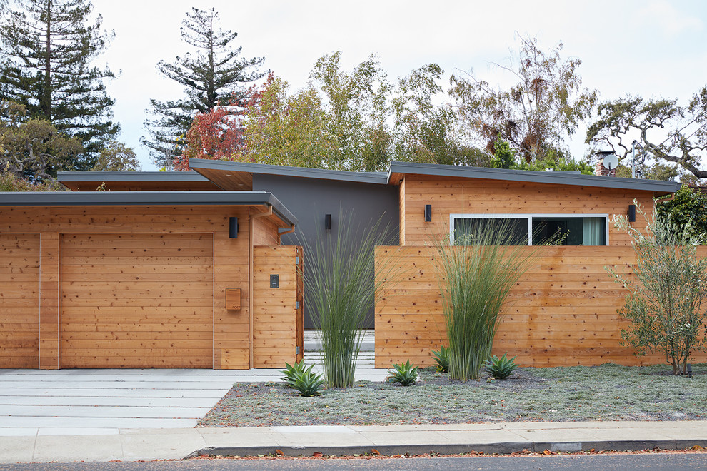 На фото: одноэтажный, деревянный, коричневый частный загородный дом среднего размера в стиле ретро с плоской крышей с