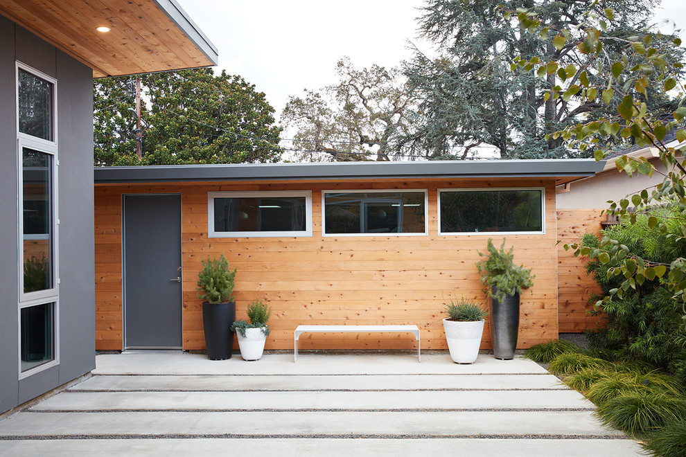Imagen de fachada de casa marrón vintage de tamaño medio de una planta con revestimiento de madera y tejado plano