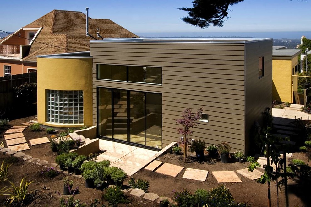Esempio della facciata di una casa marrone moderna a un piano di medie dimensioni con rivestimento in vinile e tetto piano