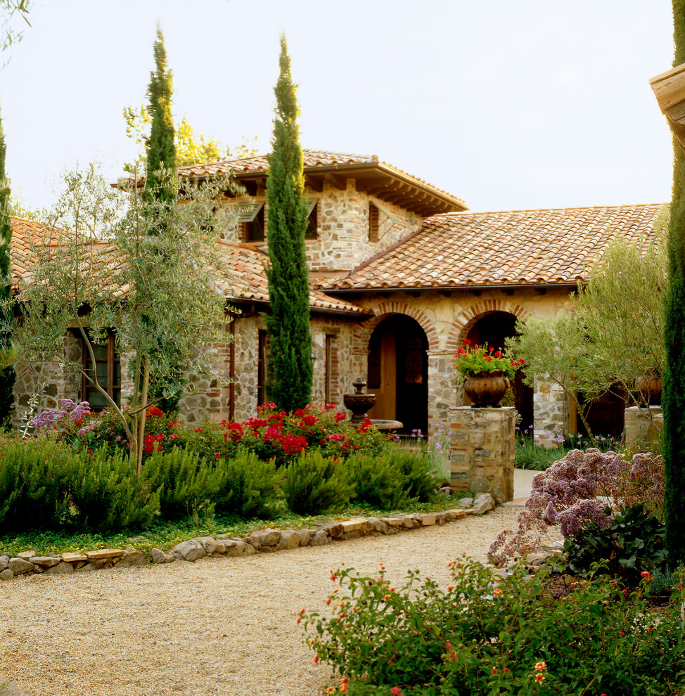 Ispirazione per la facciata di una casa mediterranea con rivestimento in pietra