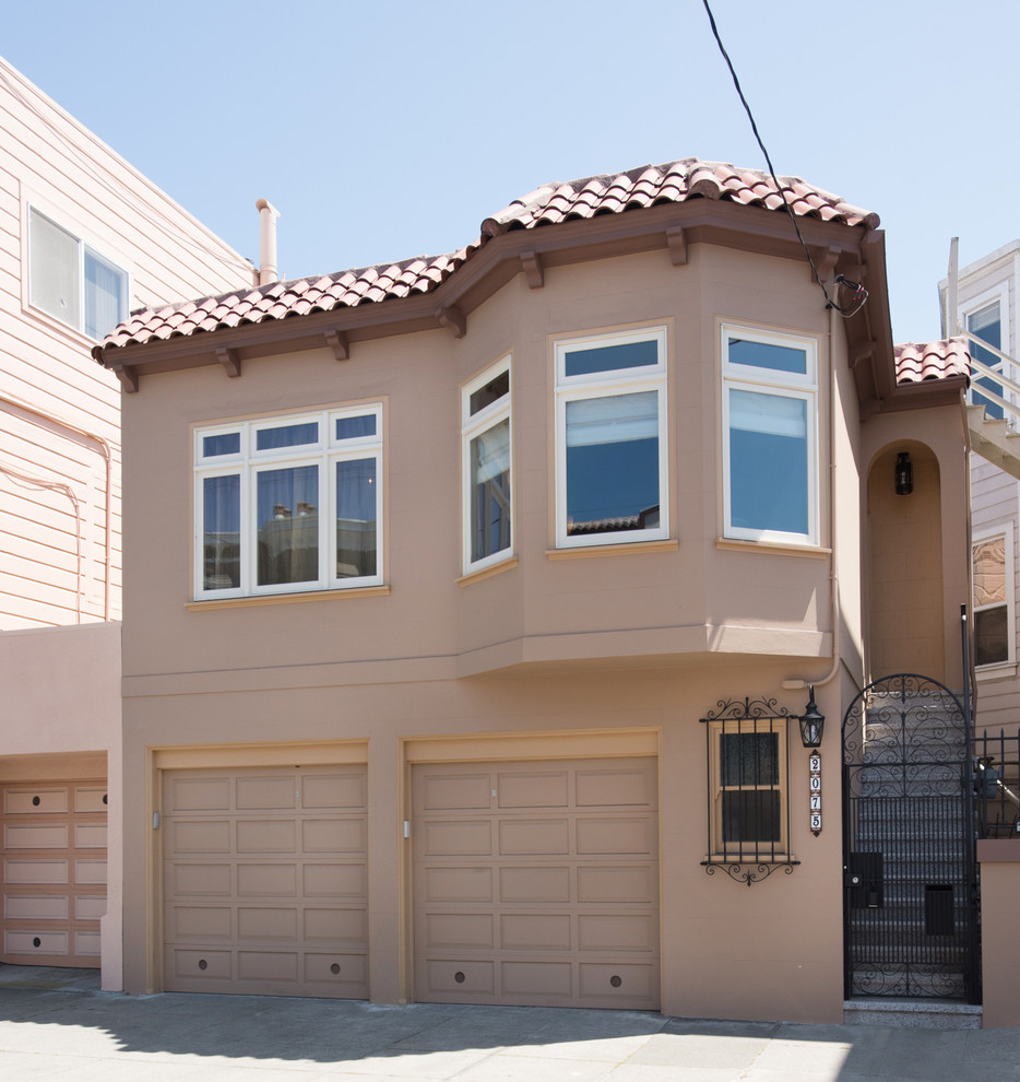 Example of a small tuscan brown one-story stucco flat roof design in San Francisco