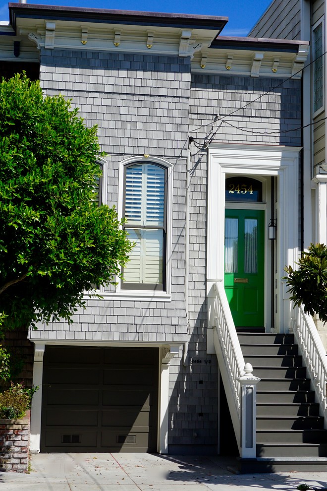 Photo of a medium sized and gey victorian house exterior in San Francisco with three floors, wood cladding and a flat roof.