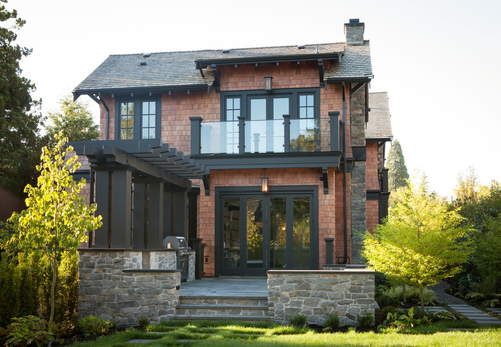 Foto della facciata di una casa marrone american style a due piani con rivestimento in legno e tetto a capanna