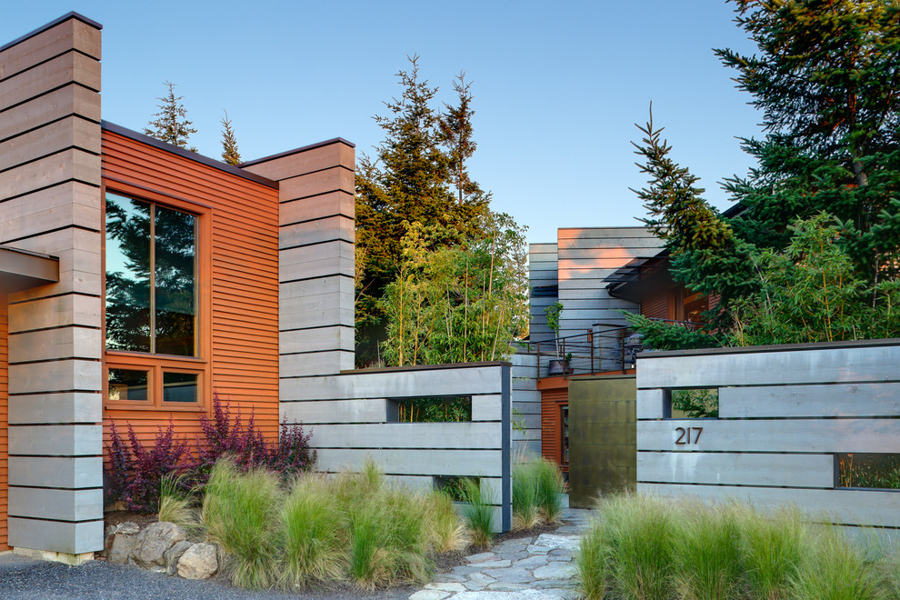 Exemple d'une grande façade de maison marron tendance en bois à niveaux décalés.