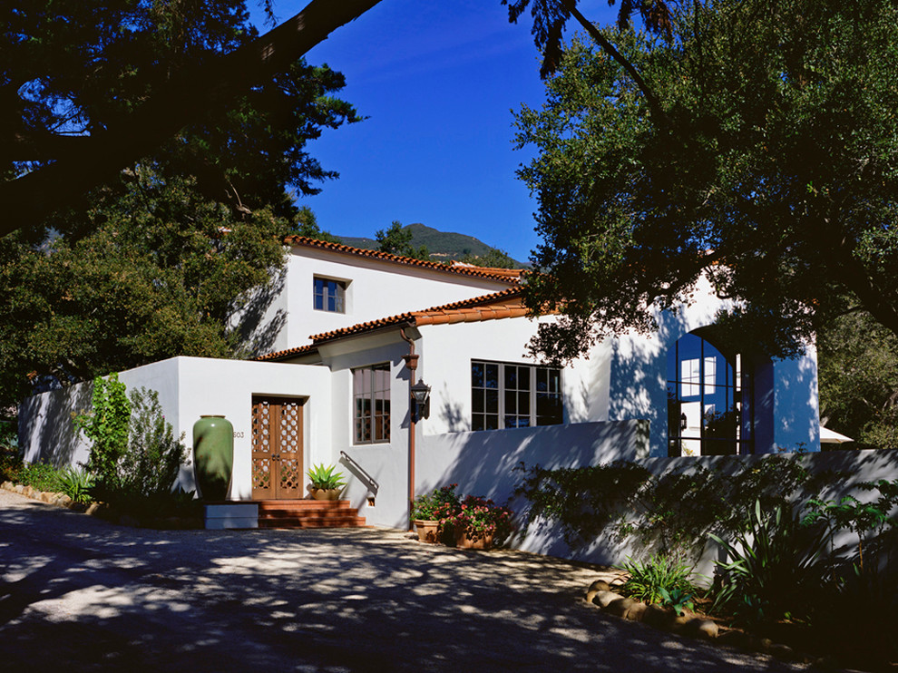 Ejemplo de fachada de casa blanca mediterránea grande de dos plantas con revestimiento de estuco y tejado de teja de barro