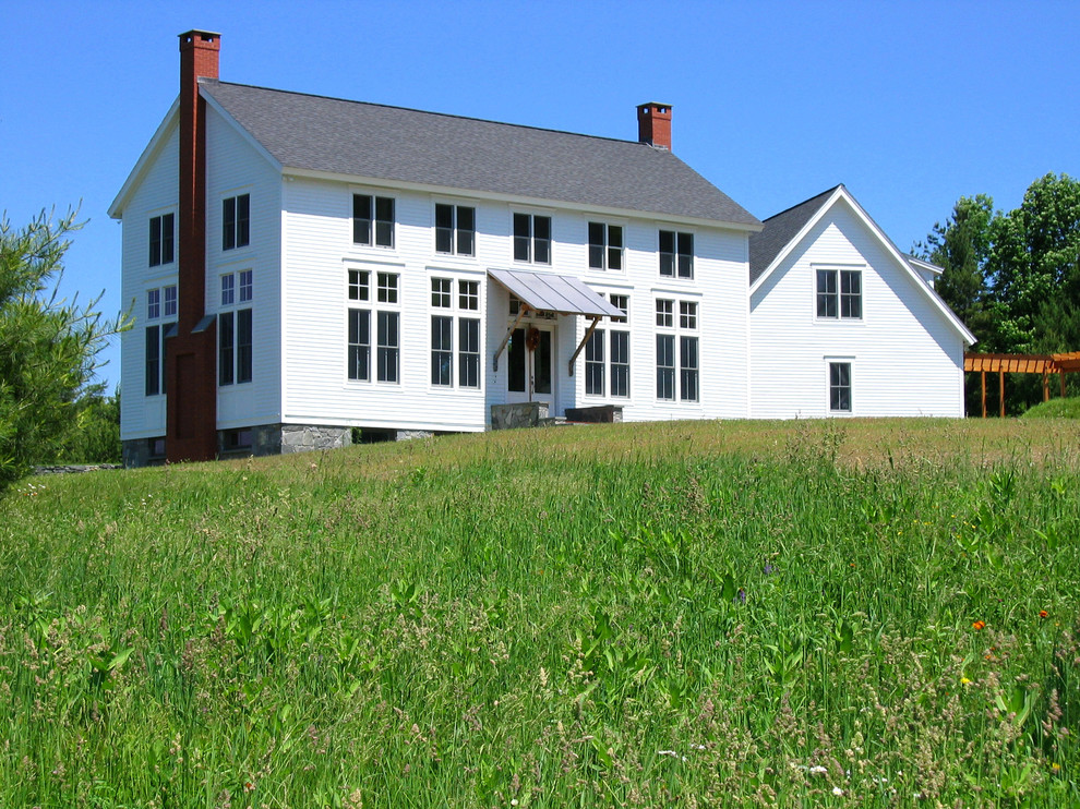 Réalisation d'une façade de maison blanche champêtre à un étage avec un toit à deux pans.