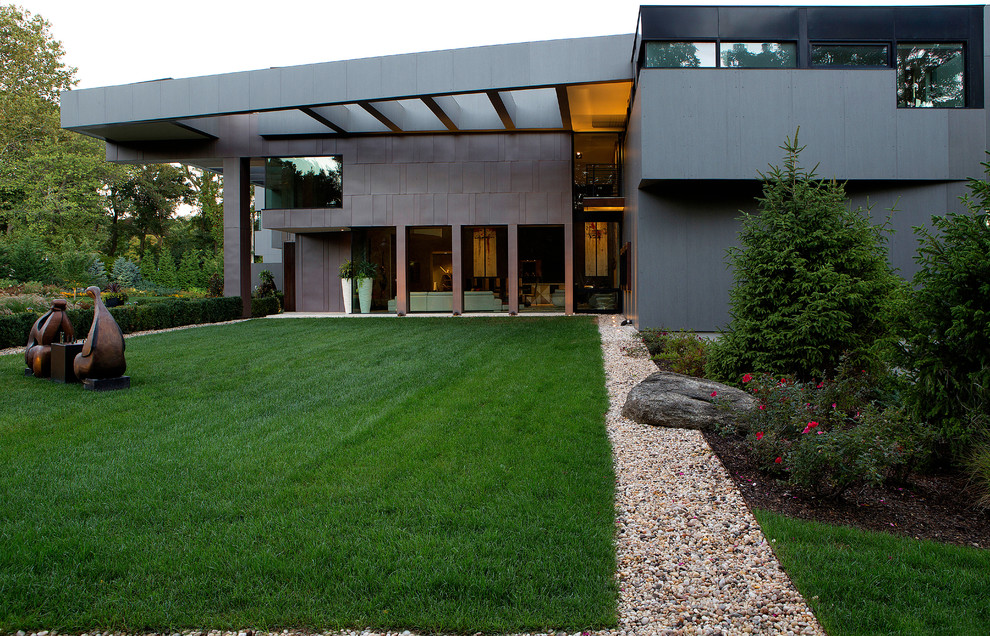 Inspiration pour une très grande façade de maison grise design à deux étages et plus avec un toit plat.