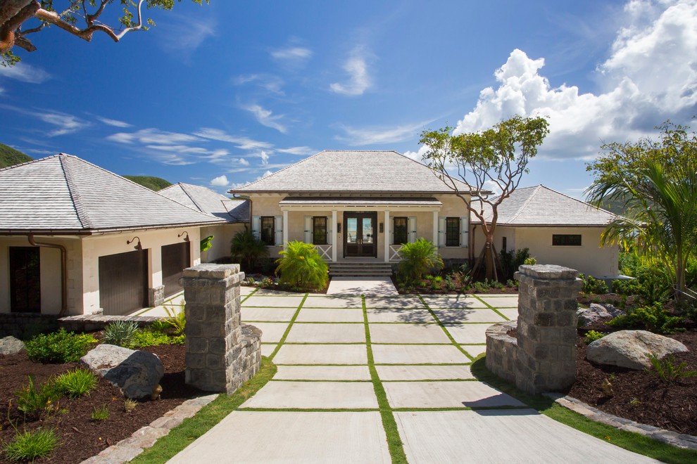 Example of an island style beige one-story exterior home design in Charleston with a hip roof