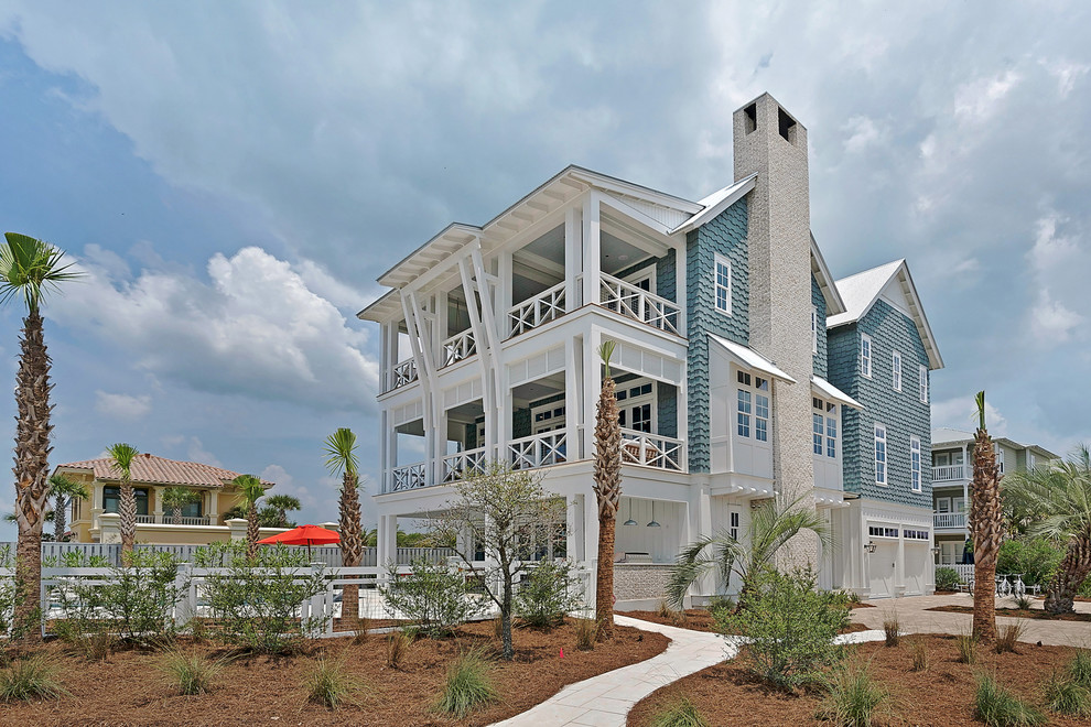 Diseño de fachada de casa azul costera extra grande de tres plantas con revestimiento de madera, tejado a dos aguas y tejado de metal