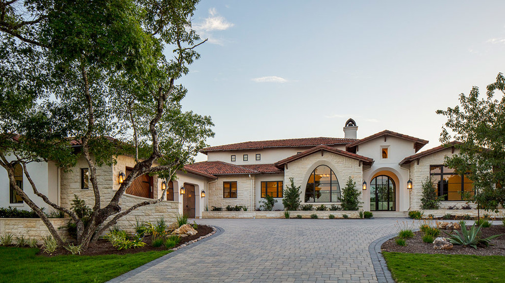 Huge mediterranean white two-story mixed siding house exterior idea in Austin with a hip roof and a tile roof