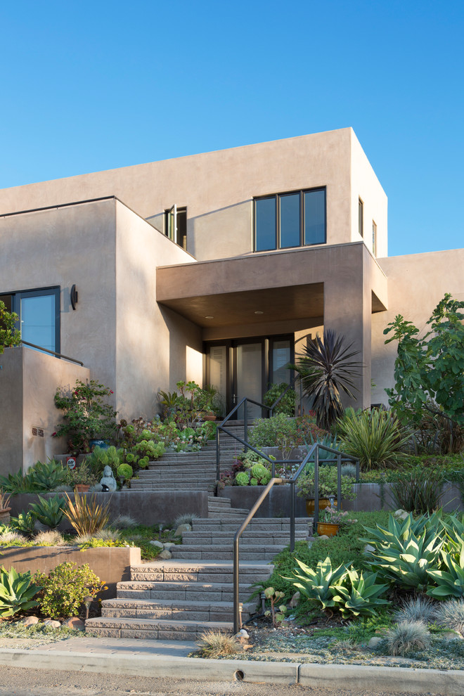 Ejemplo de fachada de casa beige de estilo americano de tamaño medio de dos plantas con revestimiento de estuco y tejado plano