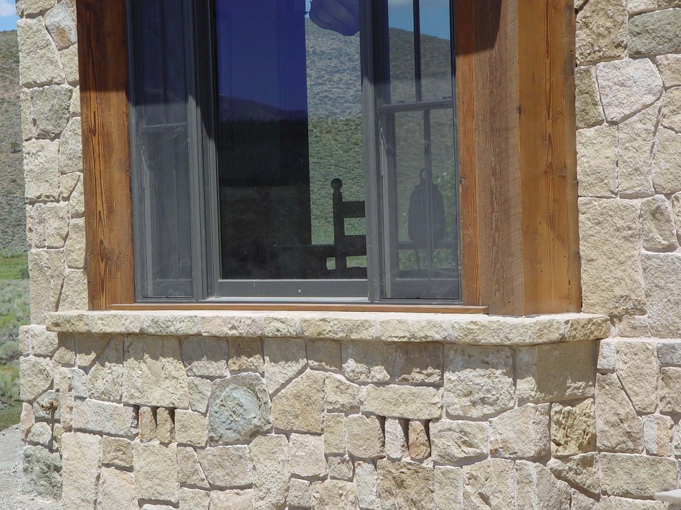 Diseño de fachada beige tradicional de tamaño medio de dos plantas con revestimiento de piedra y tejado plano