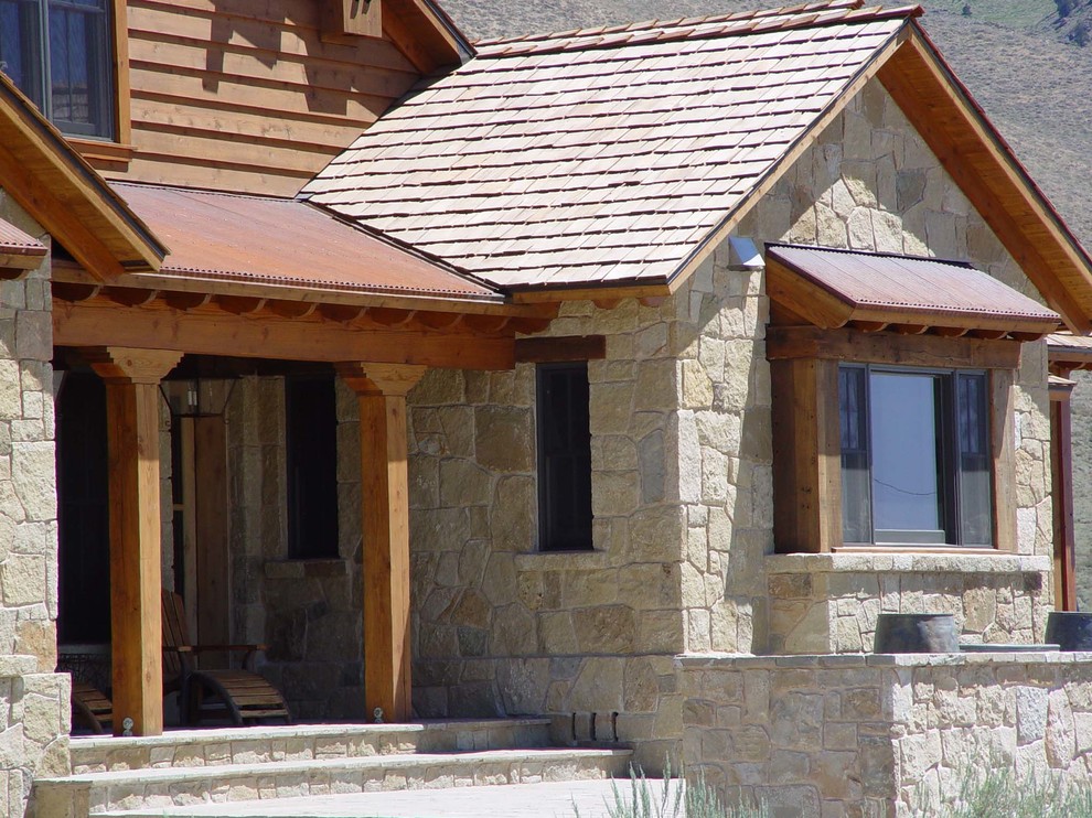 Diseño de fachada beige tradicional de tamaño medio de dos plantas con revestimiento de piedra y tejado a doble faldón