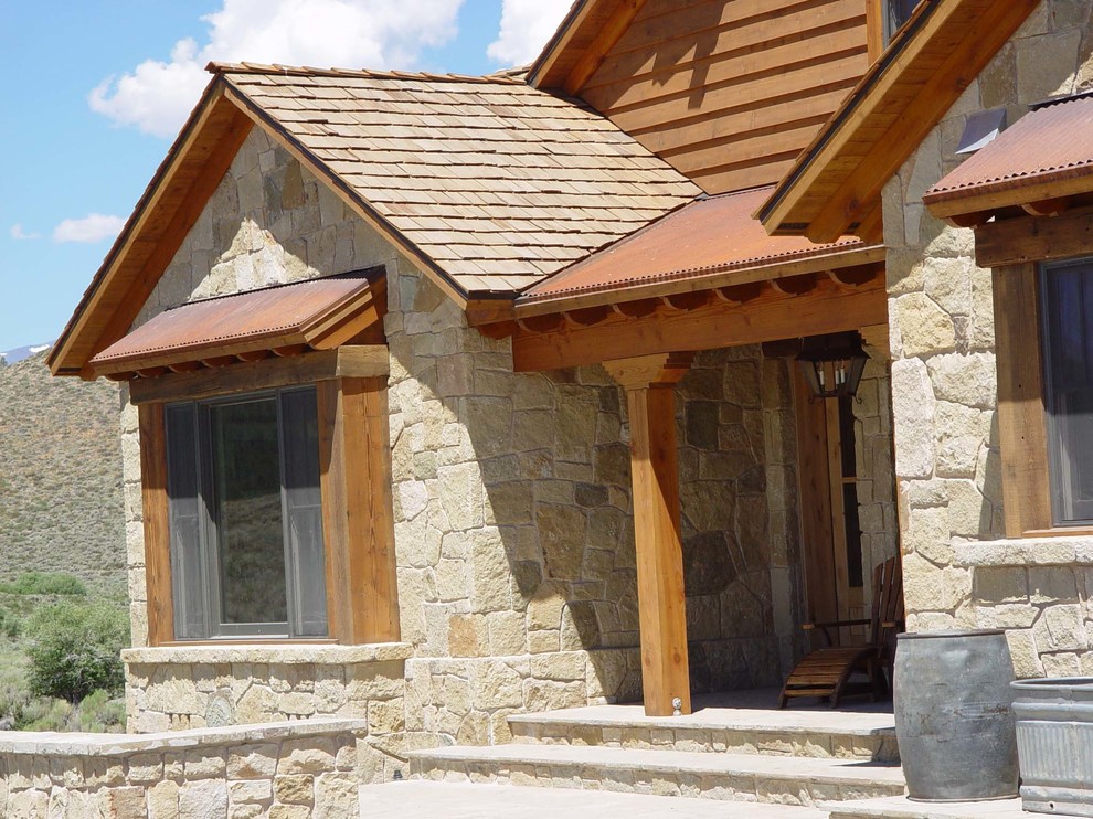 Idee per la facciata di una casa beige classica a due piani di medie dimensioni con rivestimento in pietra e tetto a mansarda