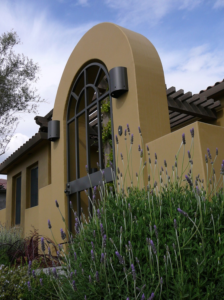 Свежая идея для дизайна: одноэтажный, желтый дом в средиземноморском стиле с облицовкой из цементной штукатурки - отличное фото интерьера