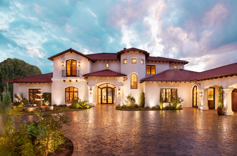 Стильный дизайн: двухэтажный, белый, большой дом в средиземноморском стиле с вальмовой крышей и облицовкой из цементной штукатурки - последний тренд