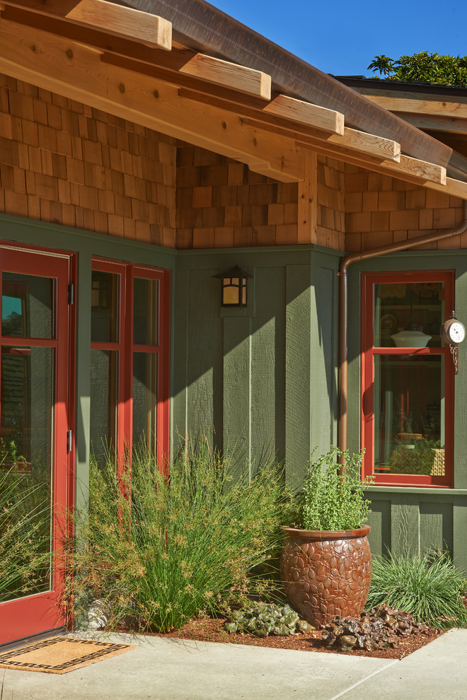 Foto de fachada de casa verde de estilo americano grande de una planta con revestimientos combinados, tejado a dos aguas y tejado de teja de madera