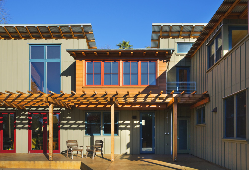 На фото: зеленый дом среднего размера в современном стиле с облицовкой из ЦСП и односкатной крышей с