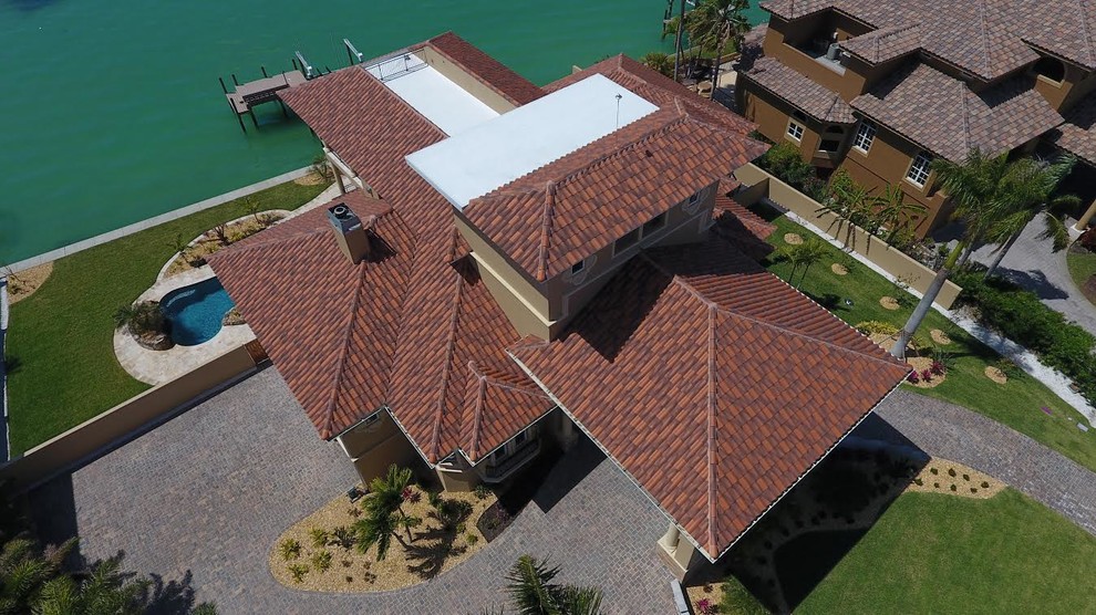 Idee per la facciata di una casa grande marrone mediterranea a tre piani con rivestimento in stucco e tetto a padiglione
