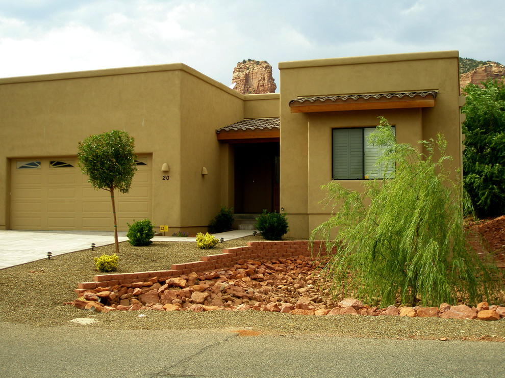 Réalisation d'une façade de maison marron sud-ouest américain en stuc de taille moyenne et de plain-pied avec un toit plat.