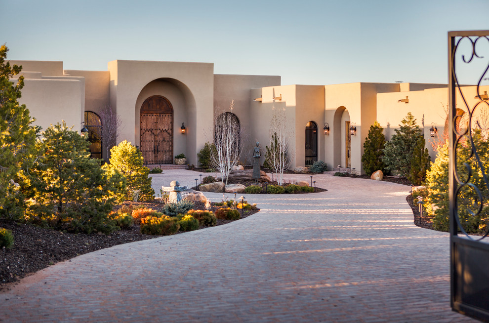 This is an example of a beige and expansive mediterranean bungalow render house exterior in Albuquerque.
