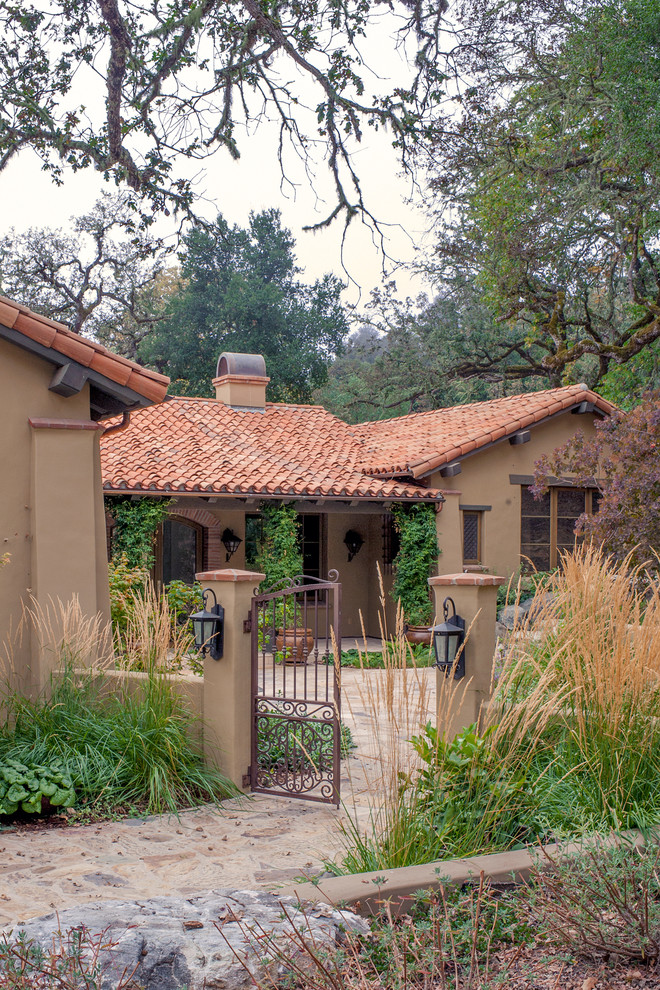 Example of a mid-sized tuscan brown one-story stucco exterior home design in Other