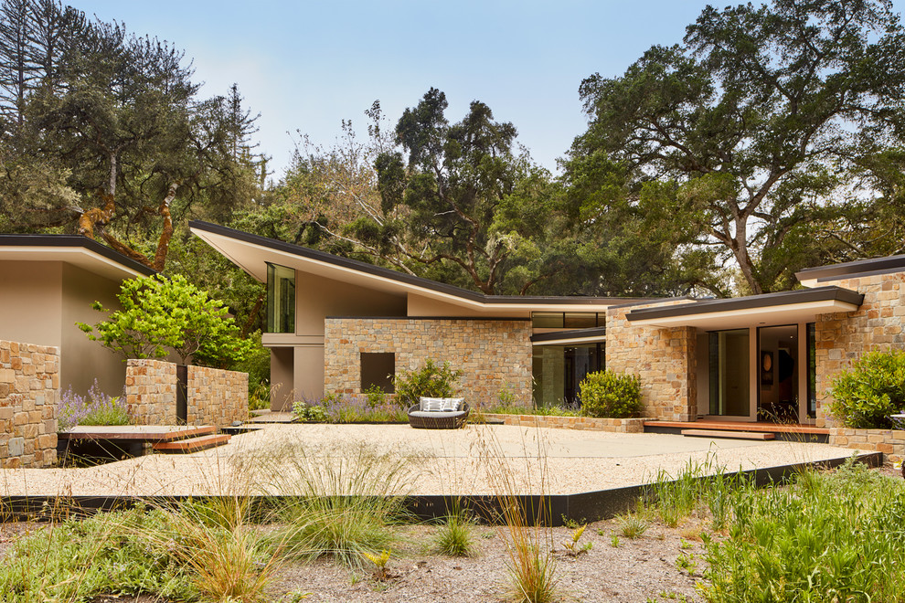 Exemple d'une façade de maison beige tendance de plain-pied avec un revêtement mixte, un toit en appentis et un toit en métal.