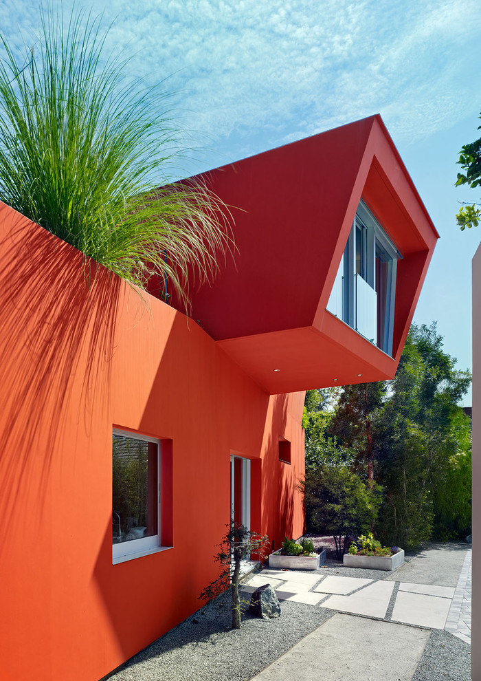 Imagen de fachada de casa naranja contemporánea de dos plantas
