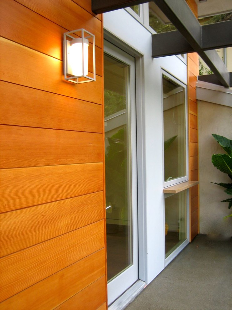 This is an example of a small contemporary bungalow house exterior in Los Angeles with wood cladding.