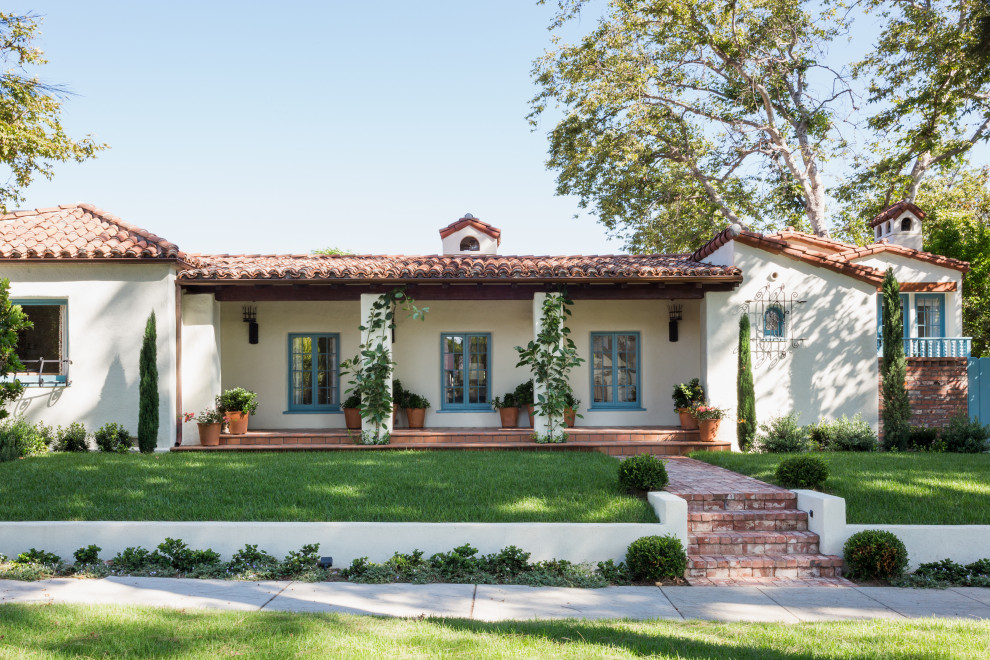 Mittelgroßes, Einstöckiges Mediterranes Einfamilienhaus mit Putzfassade, weißer Fassadenfarbe, Walmdach und Ziegeldach in Los Angeles