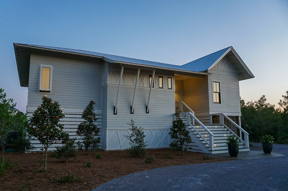 Cette image montre une façade de maison grise design de taille moyenne et de plain-pied avec un revêtement mixte et un toit à deux pans.