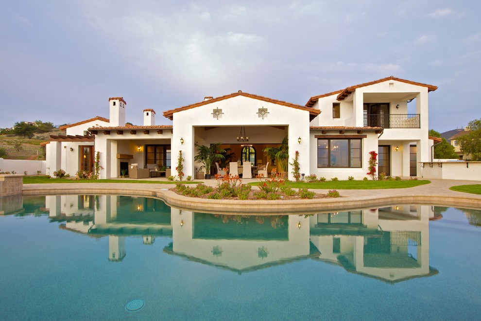 Стильный дизайн: двухэтажный, белый дом в средиземноморском стиле с облицовкой из цементной штукатурки - последний тренд