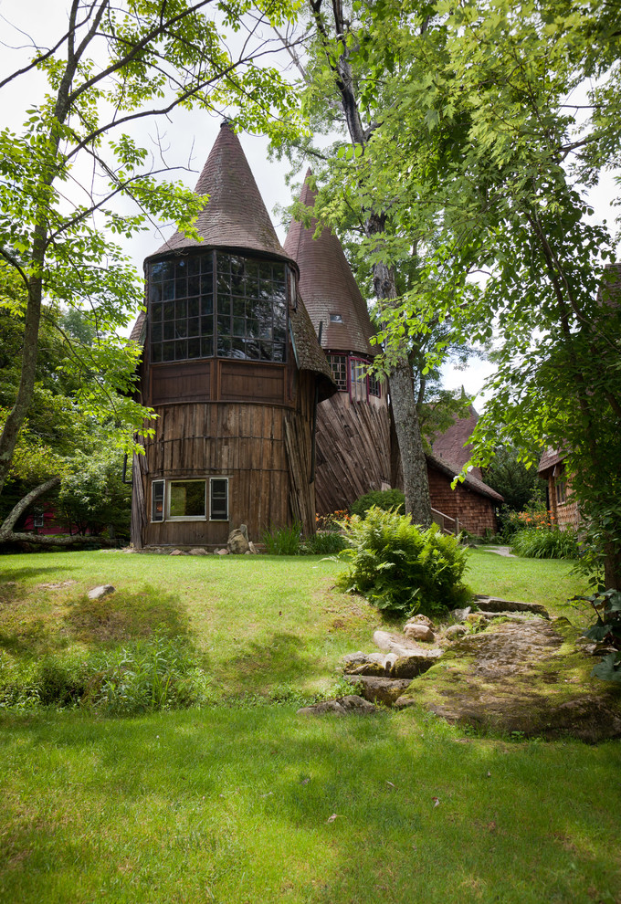 На фото: двухэтажный, деревянный, коричневый дом в стиле фьюжн с