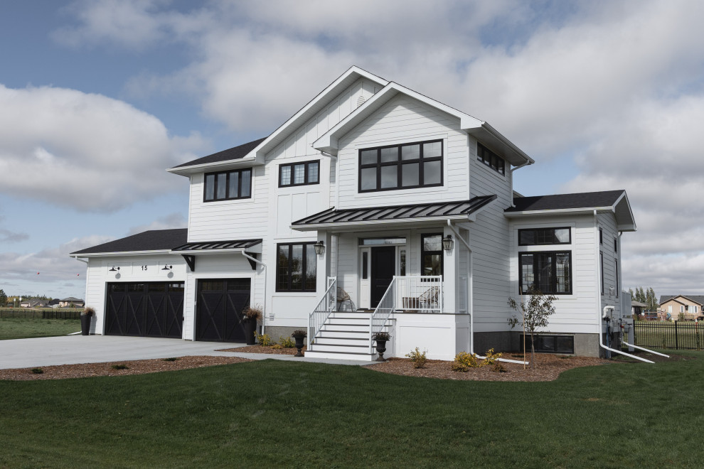 Mittelgroßes, Zweistöckiges Country Einfamilienhaus mit Mix-Fassade, weißer Fassadenfarbe und Schindeldach in Sonstige