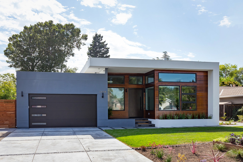 Cette photo montre une petite façade de maison multicolore tendance de plain-pied avec un toit plat et un revêtement mixte.