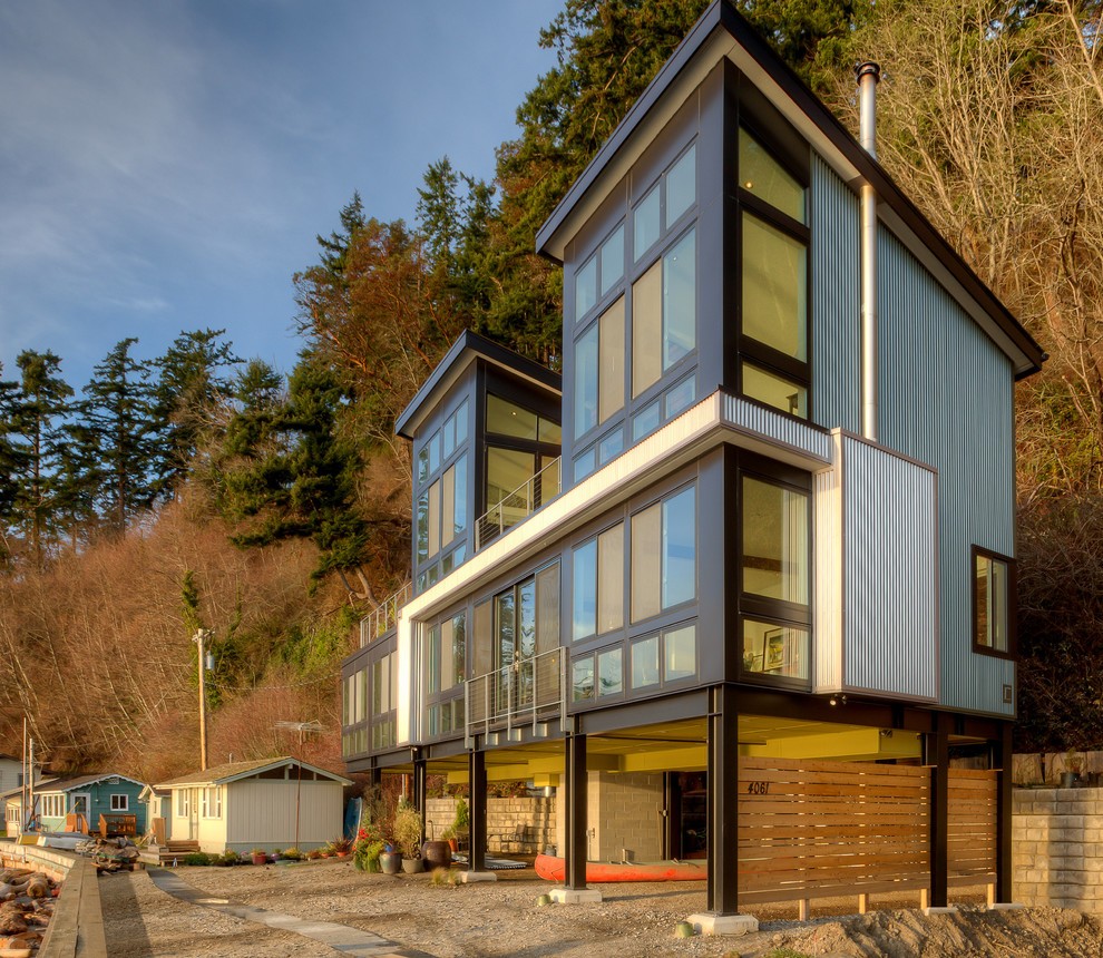 Идея дизайна: маленький, трехэтажный, серый частный загородный дом в стиле модернизм с облицовкой из металла, односкатной крышей и металлической крышей для на участке и в саду