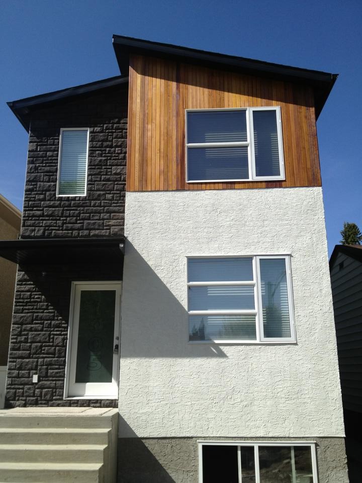 This is an example of a medium sized and white contemporary two floor brick house exterior in Other with a pitched roof.