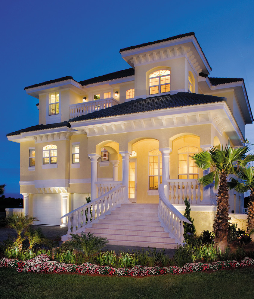 Large and yellow beach style render house exterior in Miami with three floors.