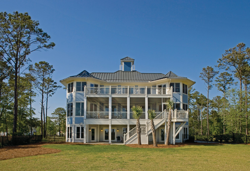 Inspiration pour une grande façade de maison bleue marine à deux étages et plus avec un revêtement en vinyle et un toit à quatre pans.