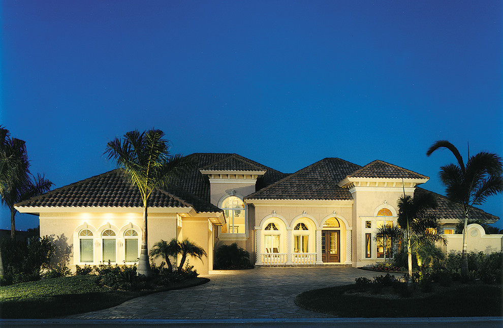 Example of a huge tuscan yellow two-story stucco exterior home design in Miami