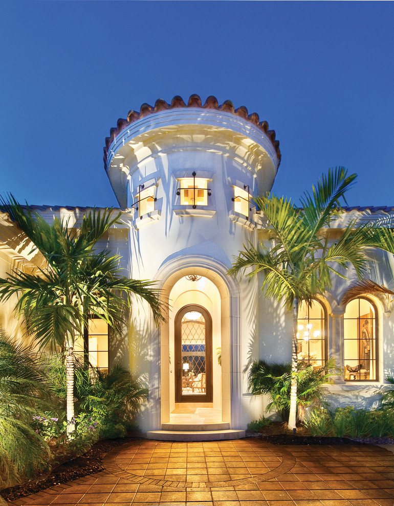 Large mediterranean beige one-story stucco exterior home idea in Miami with a hip roof